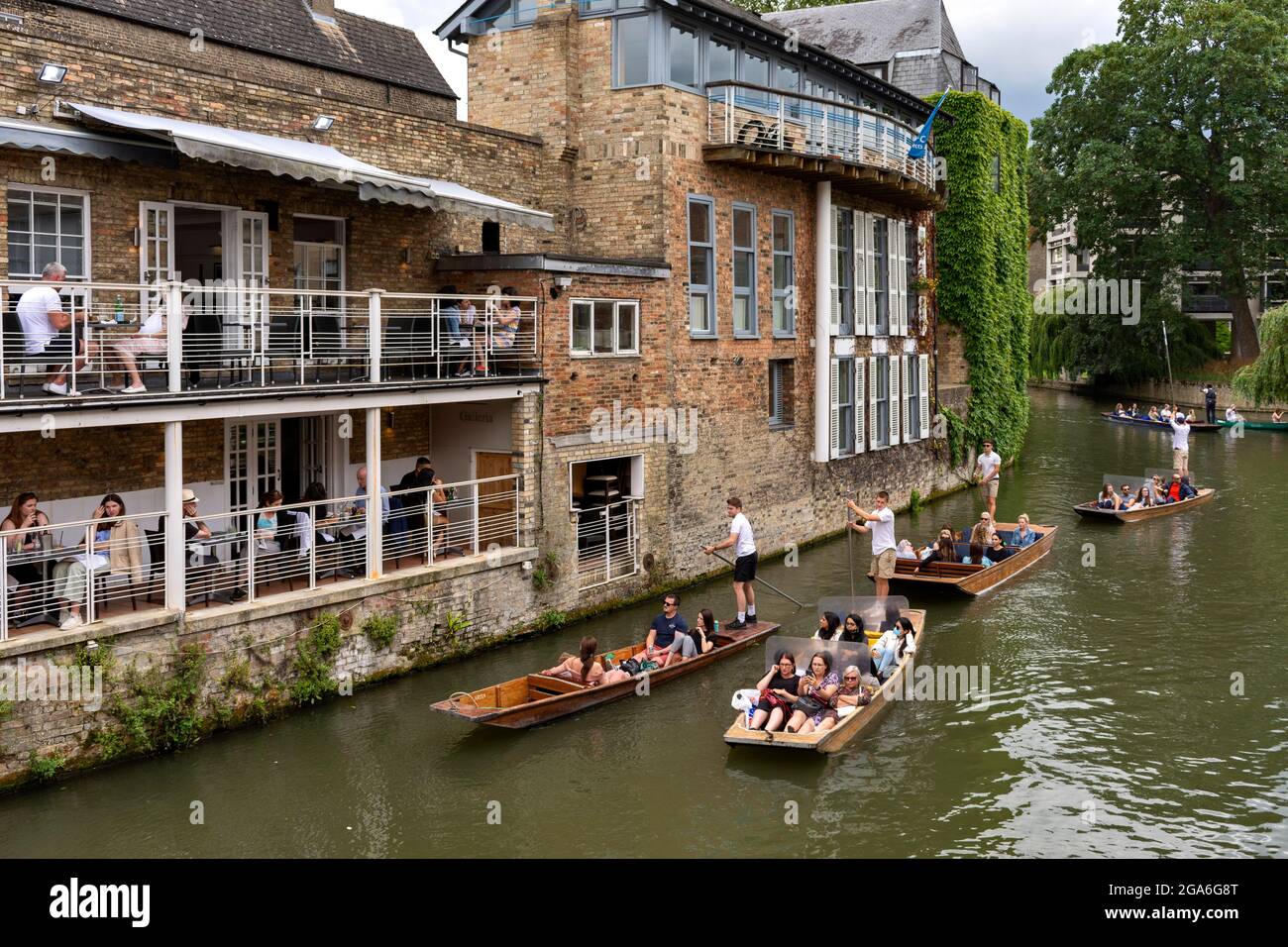 CAMBRIDGE ENGLAND RIVER CAM AT MAGDALENE BRIDGE ON A SUMMER'S WEEKEND A FLOTILLA OF PUNTS AND PASSENGERS Stock Photo