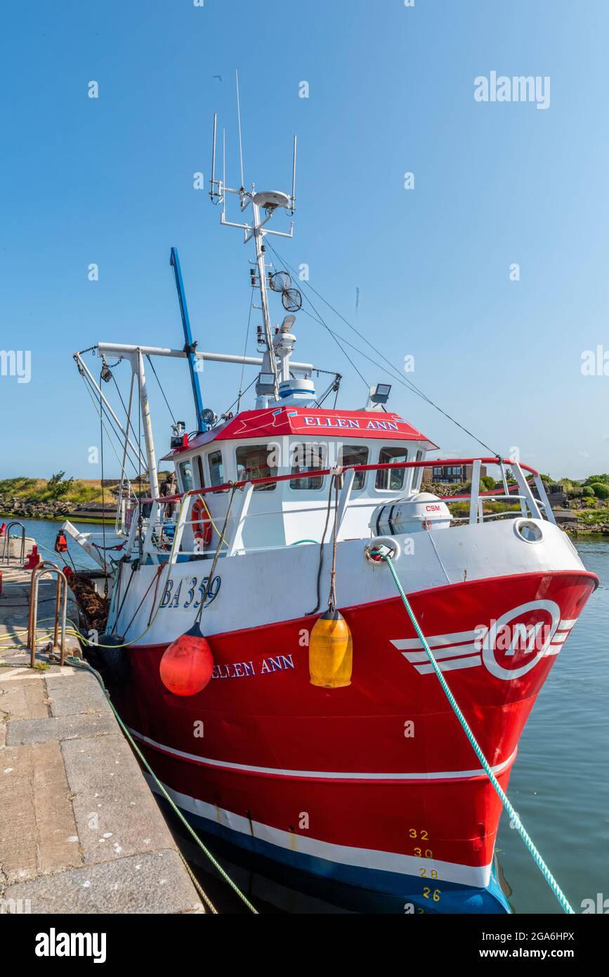 Fishing trawlers and boats alongside the wall berthed in Girvan harbour