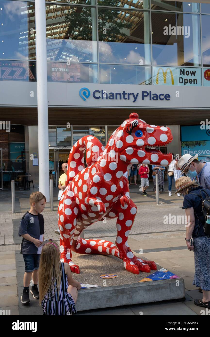 Number 3 Dinosaur painted red with white spots  standing on a plinth in front of the entrance to Chantry Place shopping mall in the centre of Norwich. Stock Photo