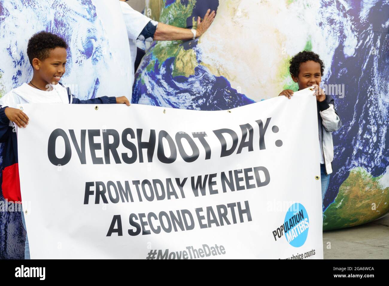 London, U.K. 29th July 2021. Earth Overshoot Day demonstration by Population Matters charity on Trafalgar Square, London. Raising awareness of overusing Earth’s natural resources by an ever increasing population and the effect this has on climate change. Many families on school holidays engaging with the charity’s inflatable Earths. Credit: Bradley Taylor / Alamy Live News Stock Photo