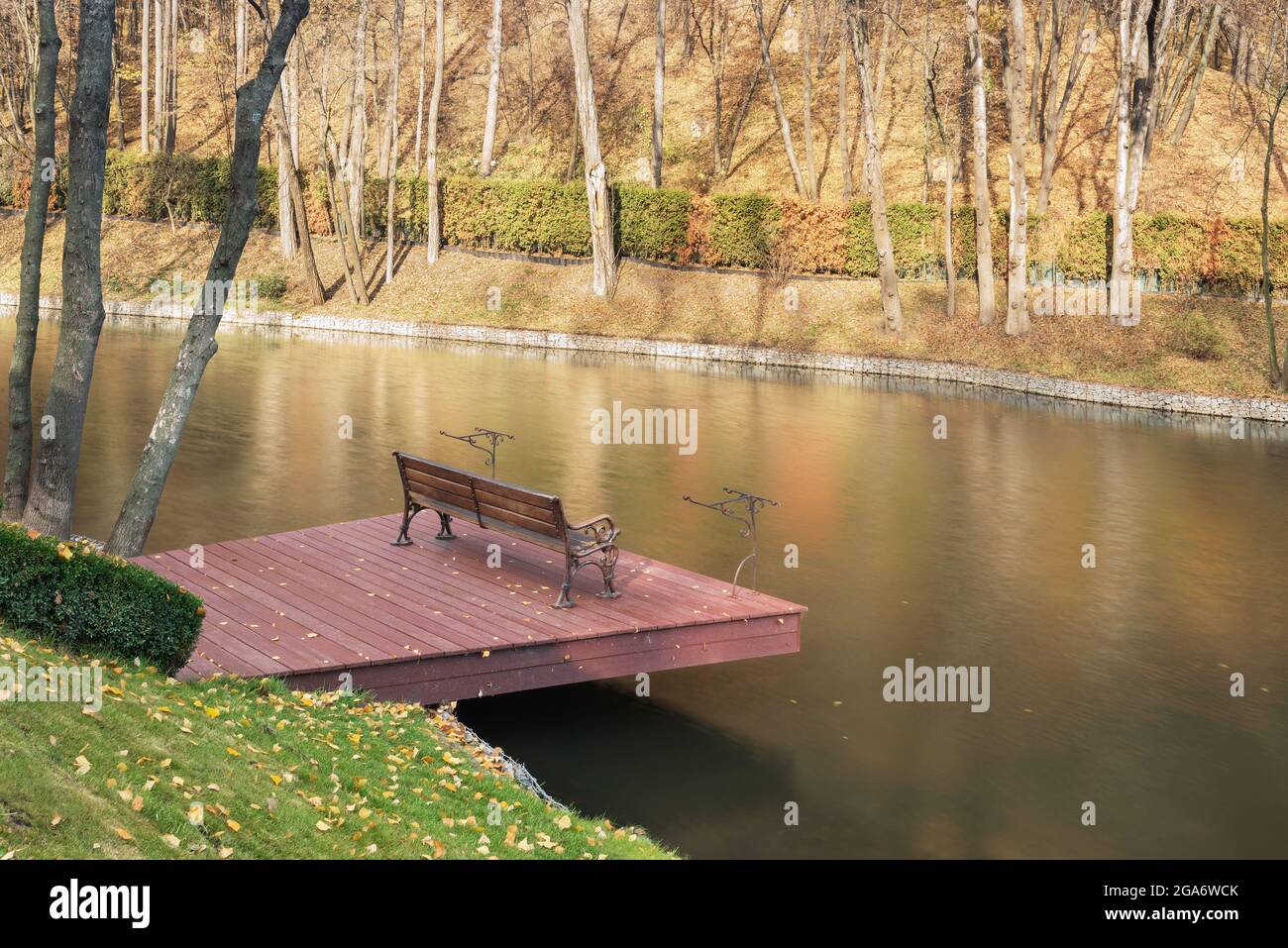 Fragment of a beautiful lake in the Mezhyhirya landscape park near Kiev, Ukraine. There is a fishing spot in the foreground. Stock Photo