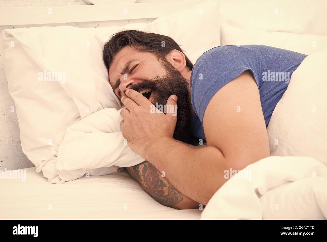 Early morning. bearded man yawn in bed. wake up at morning. bachelor feel comfortable. yawning guy at bedroom. lazy sunday. bed time routine. brutal Stock Photo