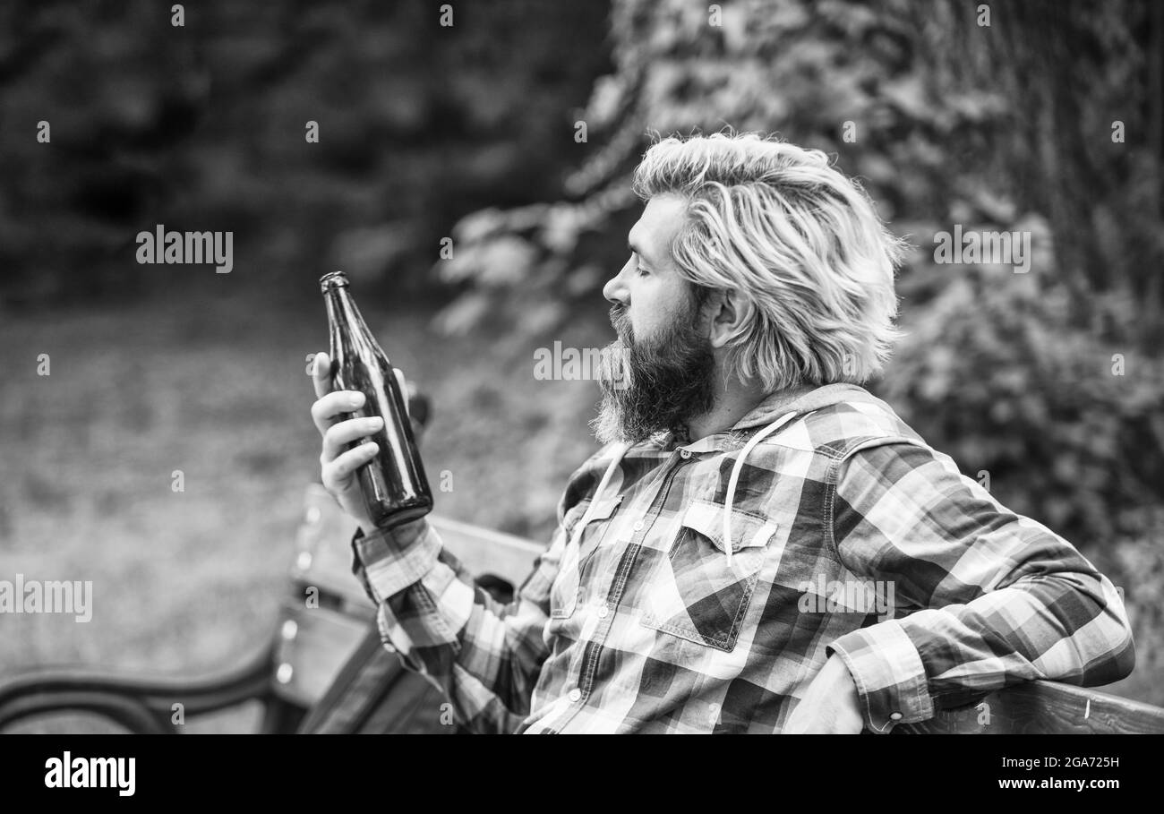 healthy water in glass bottle. brutal hipster drinking alcohol beverage. relax after work day. bearded man has hangover. mature man drink beer Stock Photo