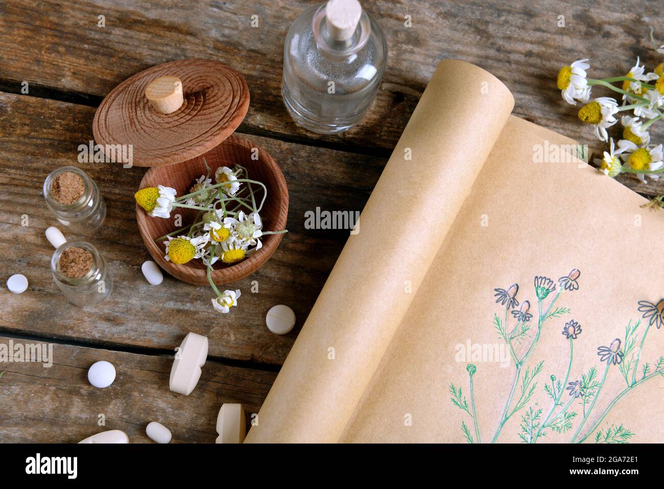 Old book with dry flowers in mortar on table close up Stock Photo