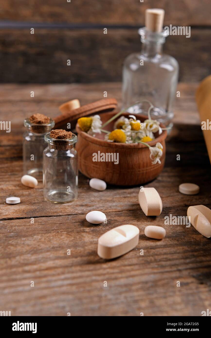 Dry flowers in mortar with tablets on table close up Stock Photo