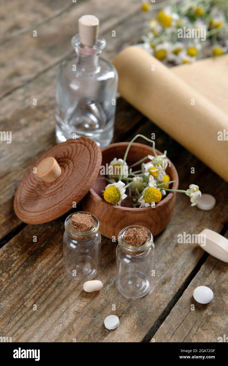 Dry flowers in mortar with tablets on table close up Stock Photo