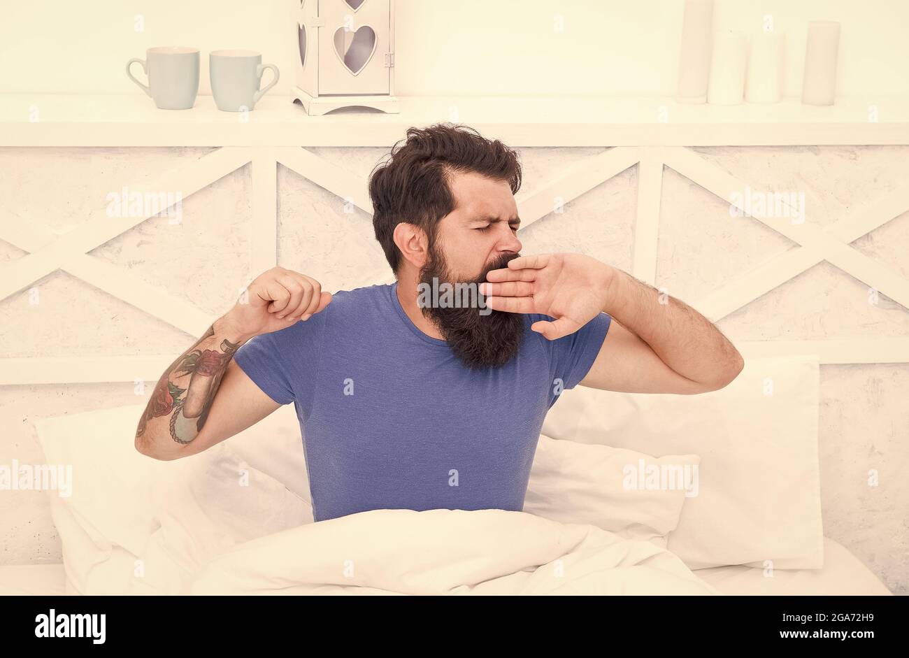 pleasant bed time routine. brutal male spending time in room. relax lifestyle concept. bearded man yawn in bed. wake up at morning. bachelor feel Stock Photo