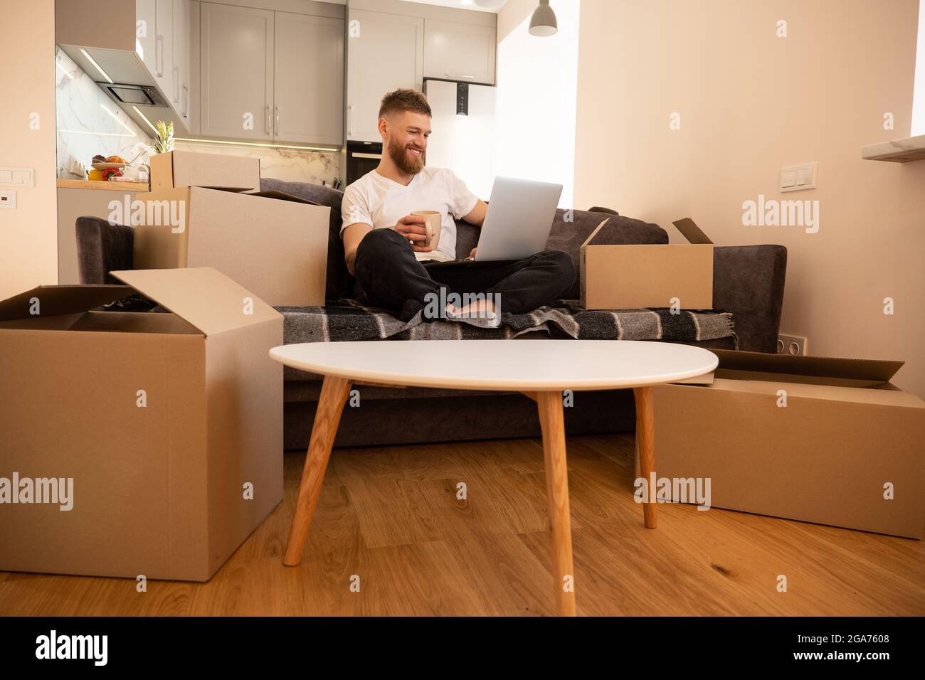 Young man using laptop computer and drinking tea Stock Photo