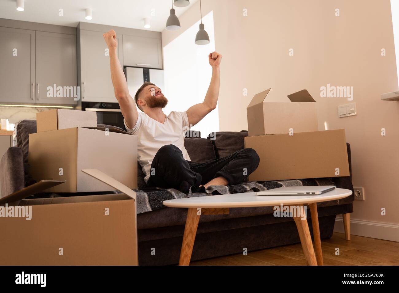 Young man sitting on sofa and joyfulling at home Stock Photo