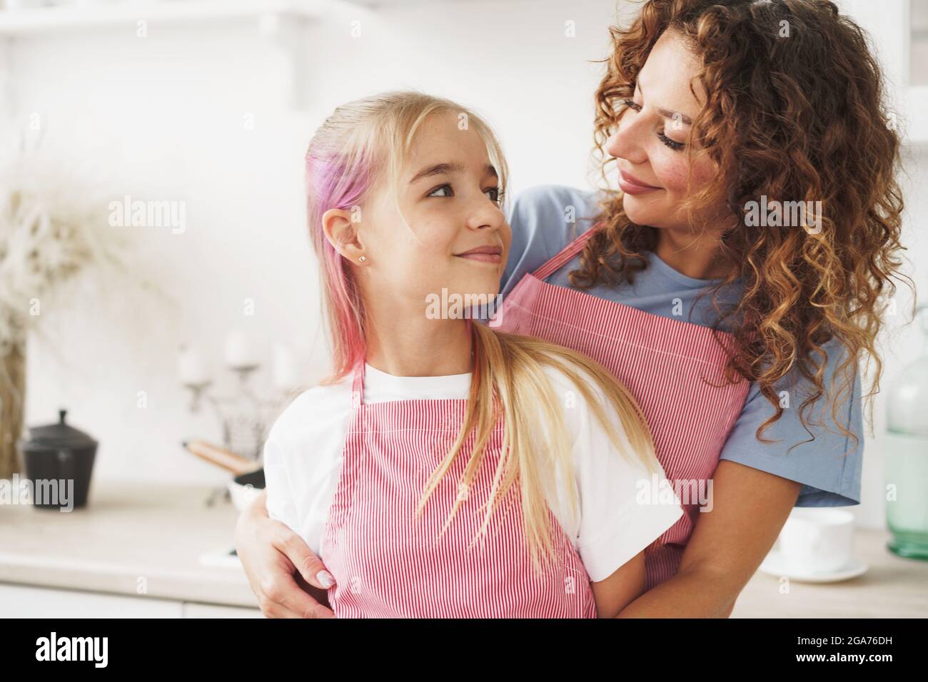 Portrait of a teen girl with her mother at home in kitchen Stock Photo ...