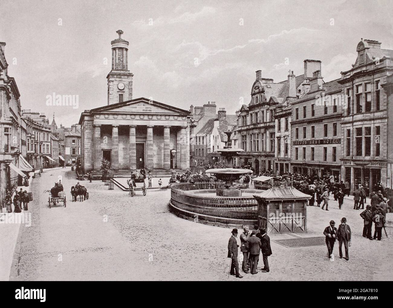A late 19th century view of the High Street in Elgin, in Moray, Scotland, a town  created as a royal burgh in the 12th century by King David I of Scotland. At the top of the street is St Giles' Church, a Church of Scotland church situated in the centre of the town.  The church was built between 1825 and 1828 and designed in a Greek Revival style by architect Archibald Simpson. Stock Photo