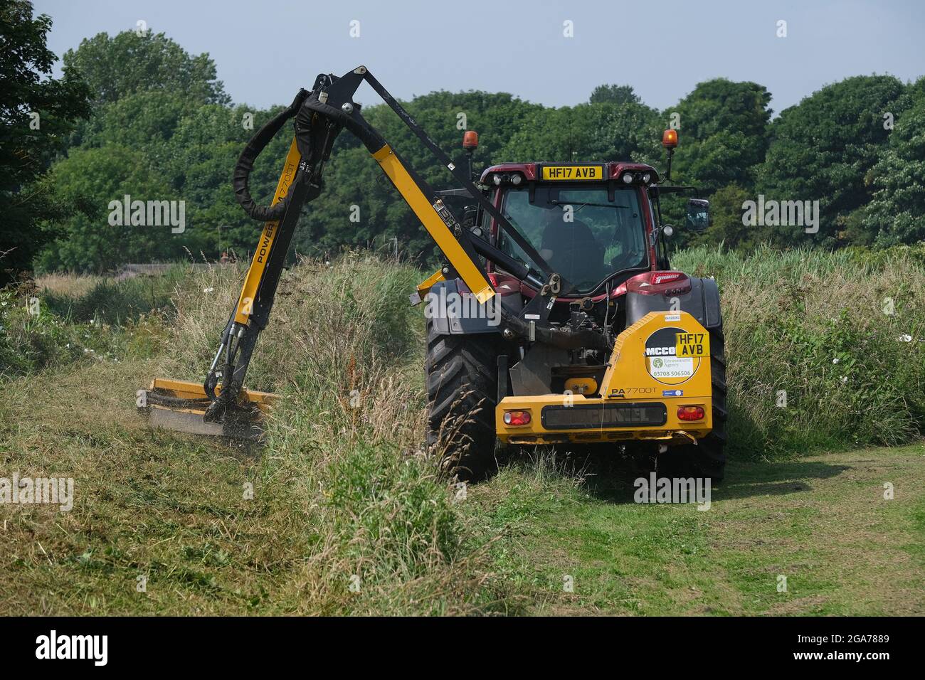Environmental agency team cutting grass and working on dykes in rural area. Stock Photo