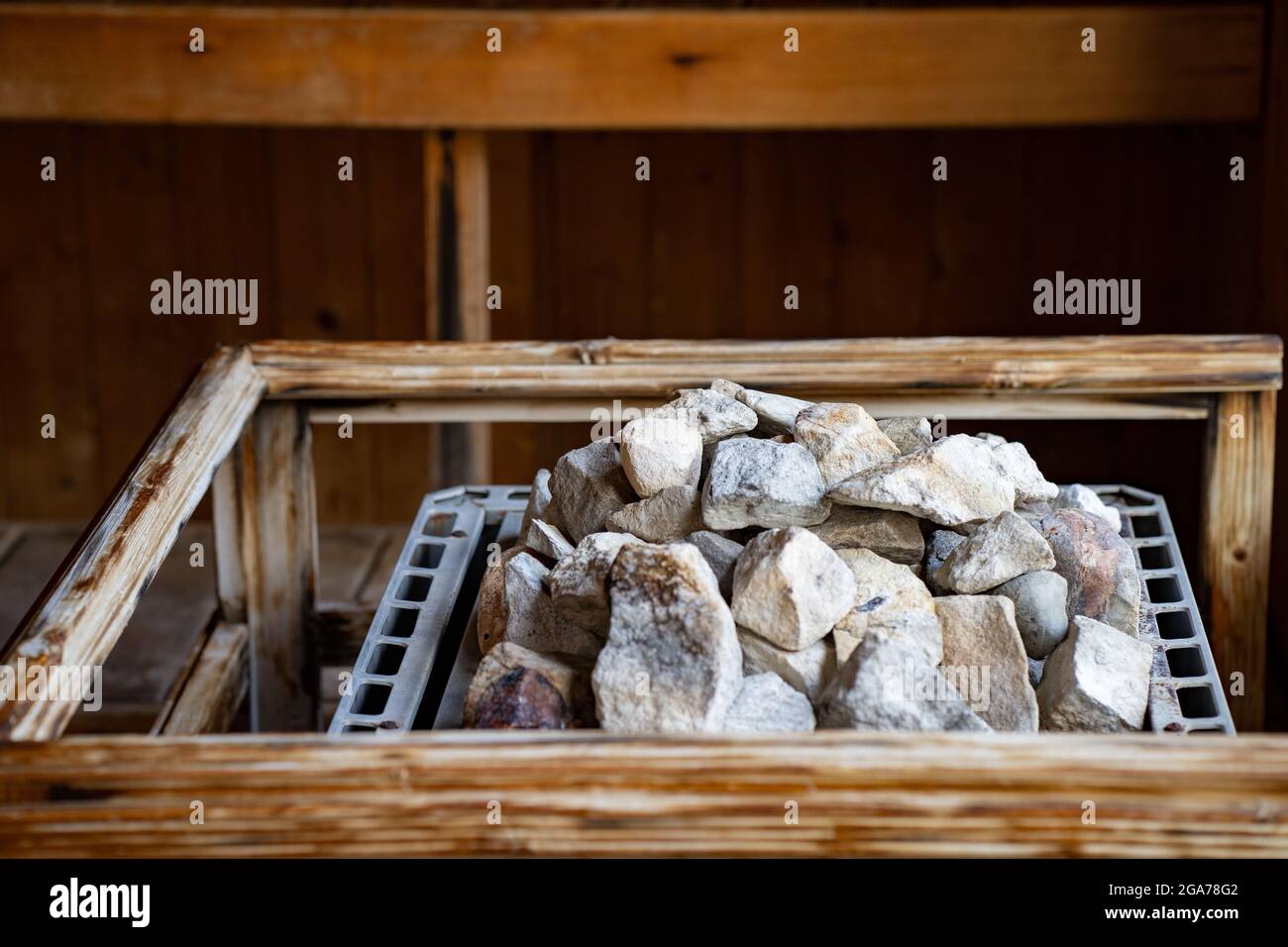 Heap of stones on a metal shelf in a wooden container Stock Photo