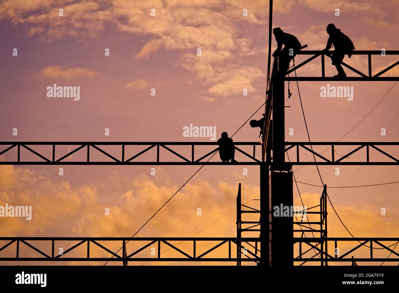 Group of workers working in construction site at sunset Stock Photo