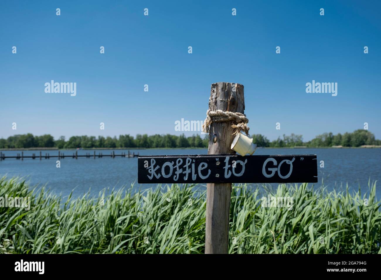 Wooden Sign with dutch words koffie to go 'Coffee to go' on the background of wooden board in a outside environment in the Netherlands Stock Photo