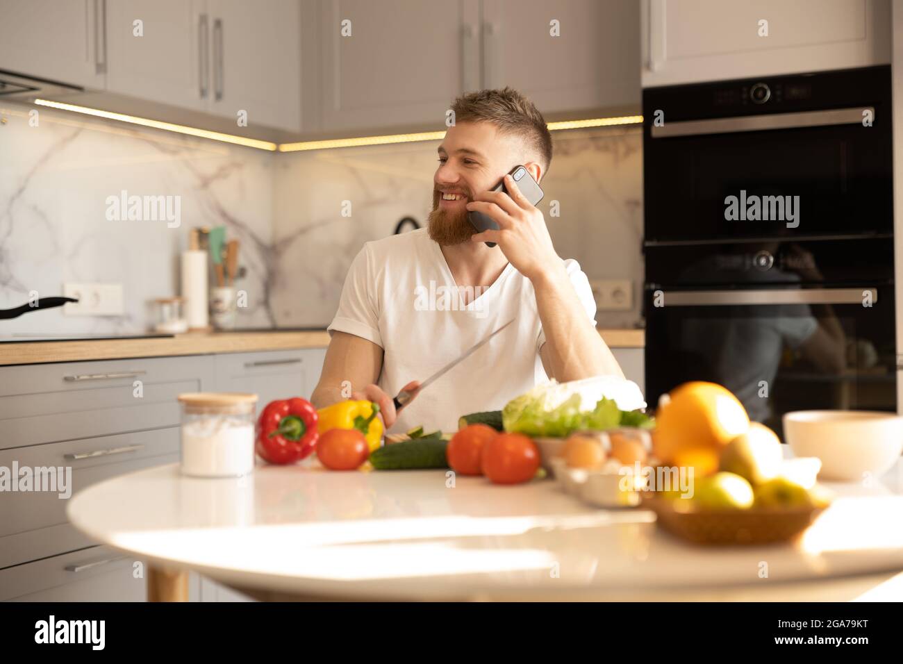Man talking on mobile phone while sitting at table Stock Photo
