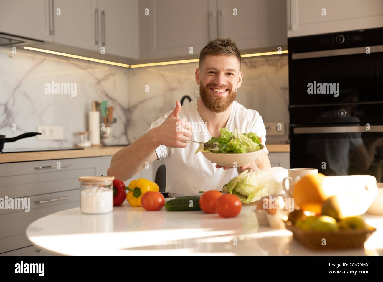 Man showing salad in bowl and thumb up gesture Stock Photo