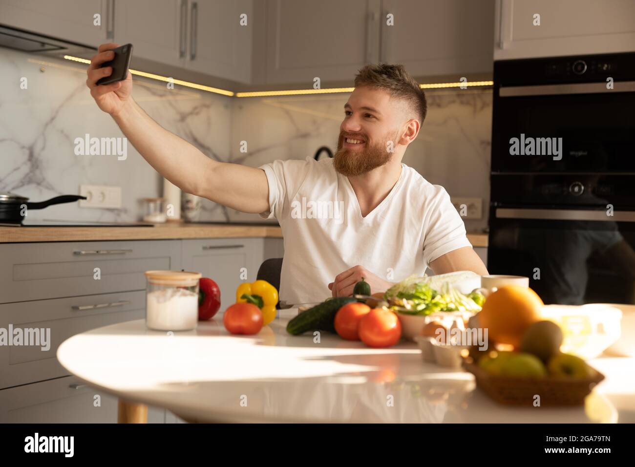 Young man take selfie on mobile phone at table Stock Photo