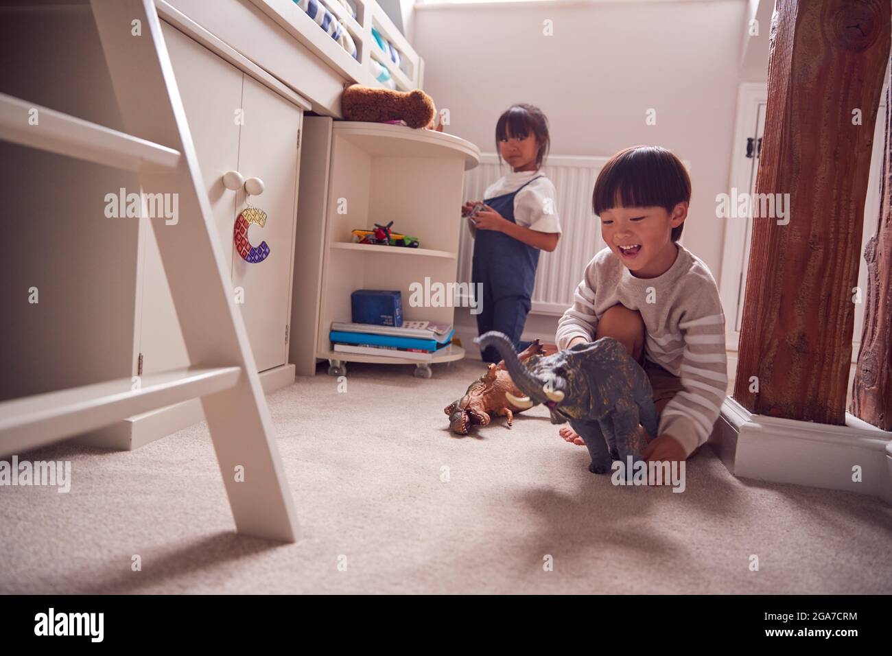 Asian Children Having Fun Playing With Toys In Bedroom Together Stock