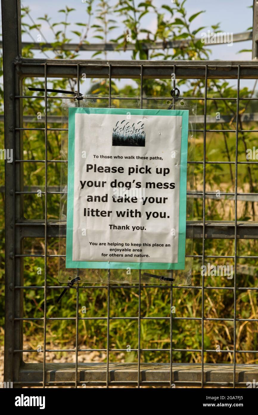 Countryside sign instructing dog owners to pick up dogs mess (poo) and take litter home with you, Summer July 2021, Surrey, UK Stock Photo