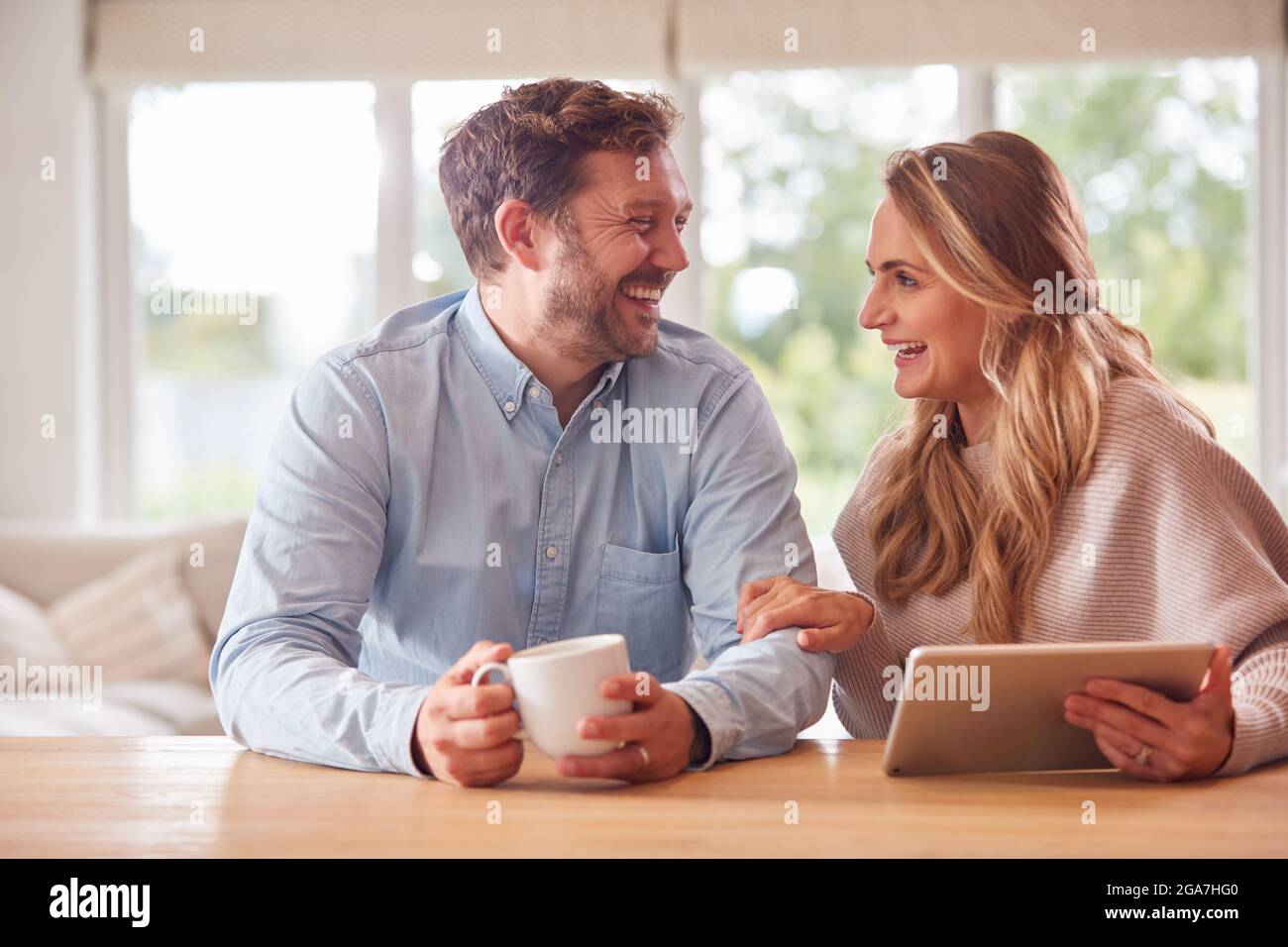 Couple At Home Buying Products Or Services Online Using Digital Tablet Stock Photo