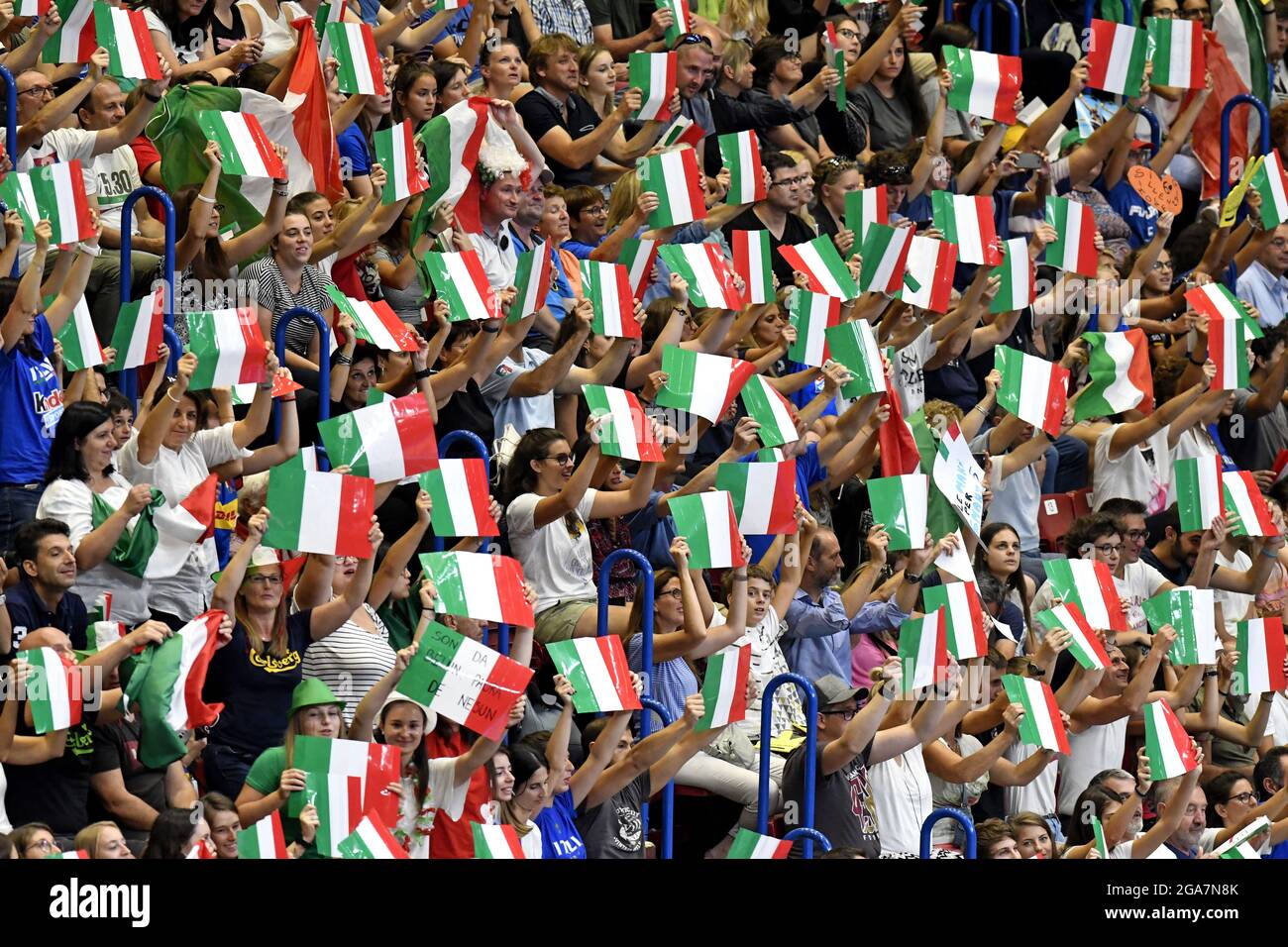 Italian fans cheering and waving Italian flags at the indoor Forum arena, during the Volleyball Men's World Championship, in Milan. Stock Photo