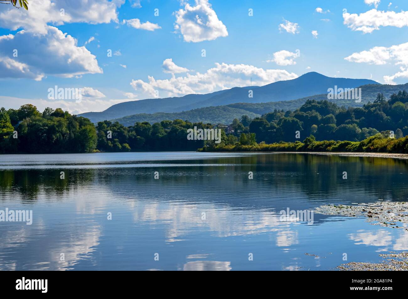 A summertime blue sky and mountain view are reflected in a lake in Vermont, USA. Copy space. Stock Photo