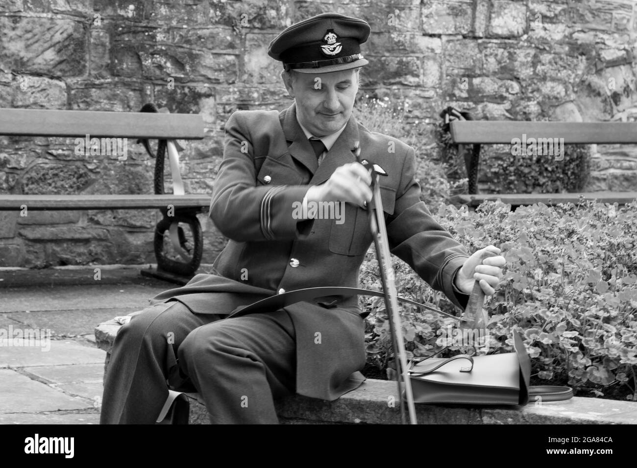 A man wearing a British Royal Air Force uniform playing a musical saw with a bow during a1940's weekend, Nidderdale, England, UK. Stock Photo