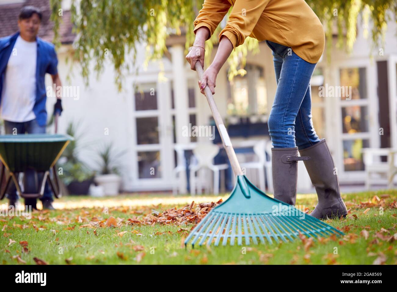 Asian woman raking leaves hi-res stock photography and images - Alamy