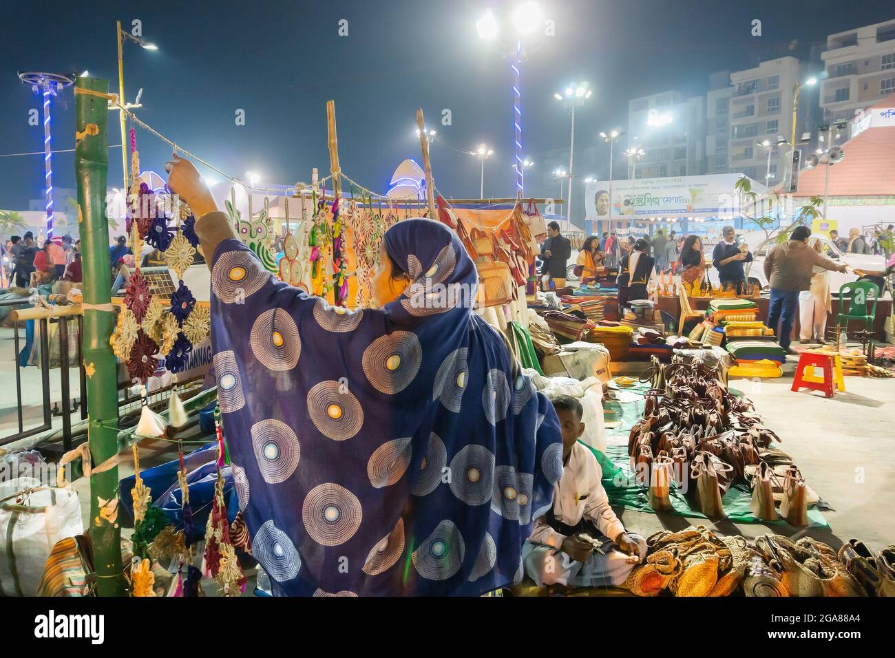 Kolkata, West Bengal, India - 31st December 2018 : Seller woman arranging handmade jute products, handicrafts for sale at night during Handicraft Fair Stock Photo