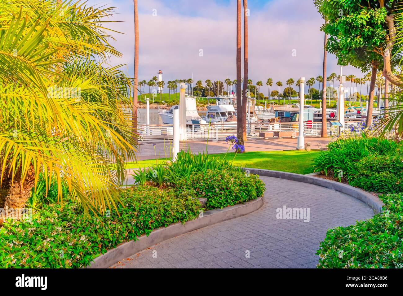 Pathway leads to Rainbow Harbor in the dusk light with the Pier Point Landing lighthouse standing above it guarding it in Long Beach, California Stock Photo