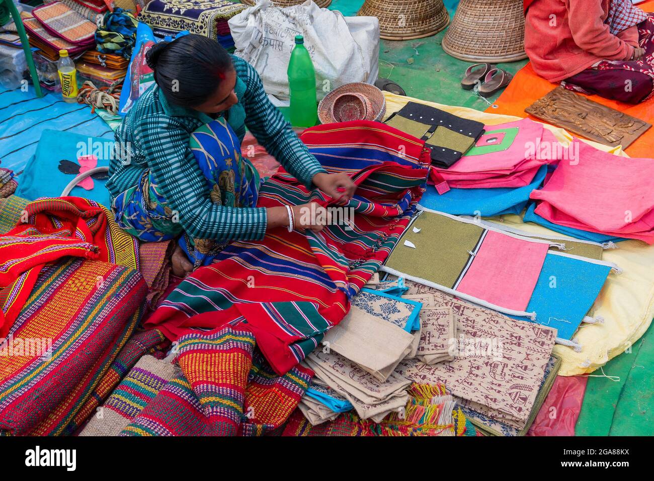 Kolkata, West Bengal, India - 31st December 2018 : Young Bengali woman selling carpets, door mats, handicraft products at hastashilpomela or handicraf Stock Photo