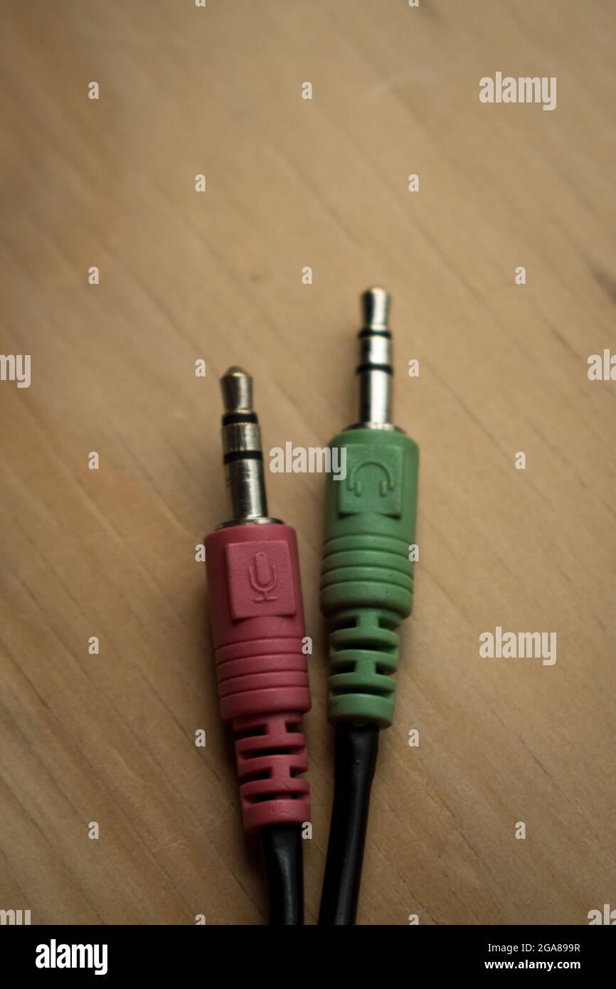 Colorful earphones cables connection on a wooden table Stock Photo