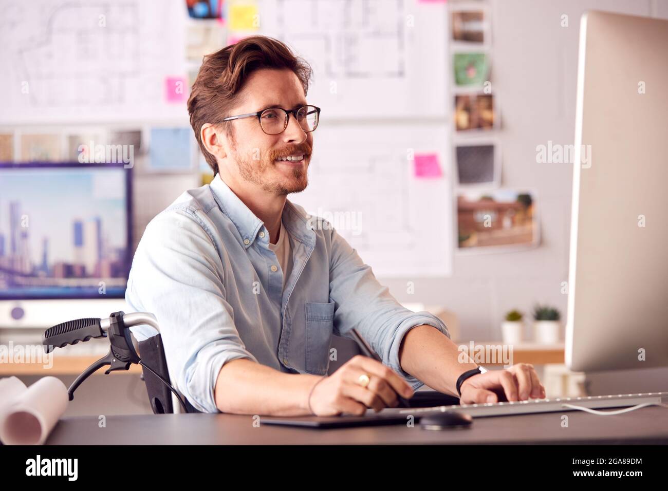 Disabled Female Architect In Wheelchair In Office Working On Desktop ...