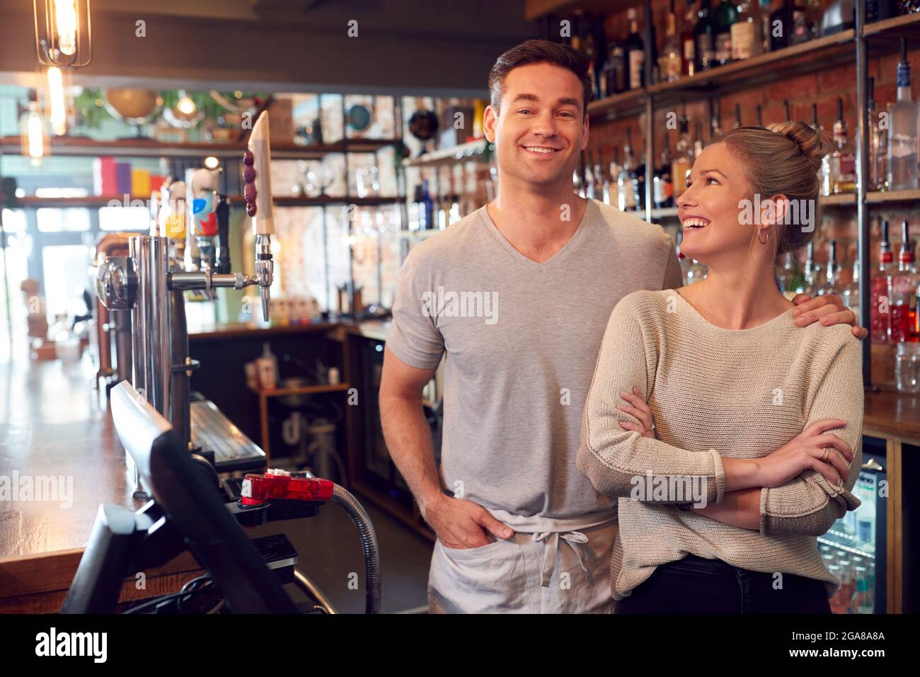 Portrait Of Smiling Couple Owning Bar Standing Behind Counter Stock Photo