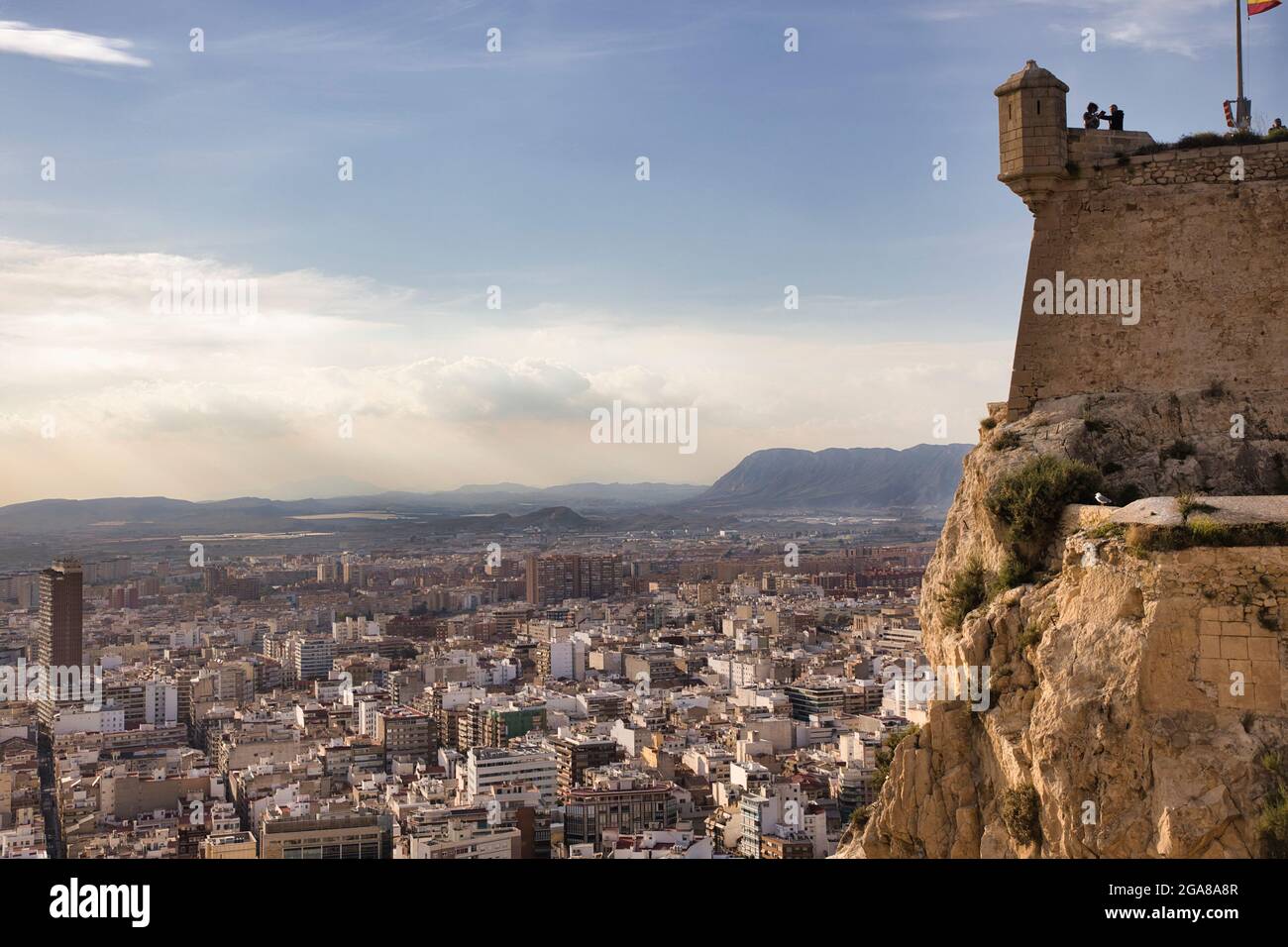 A section of the high castle wall of Santa Barbara castle at Alicante, Spain with a corner turret, overlooking the city below Stock Photo