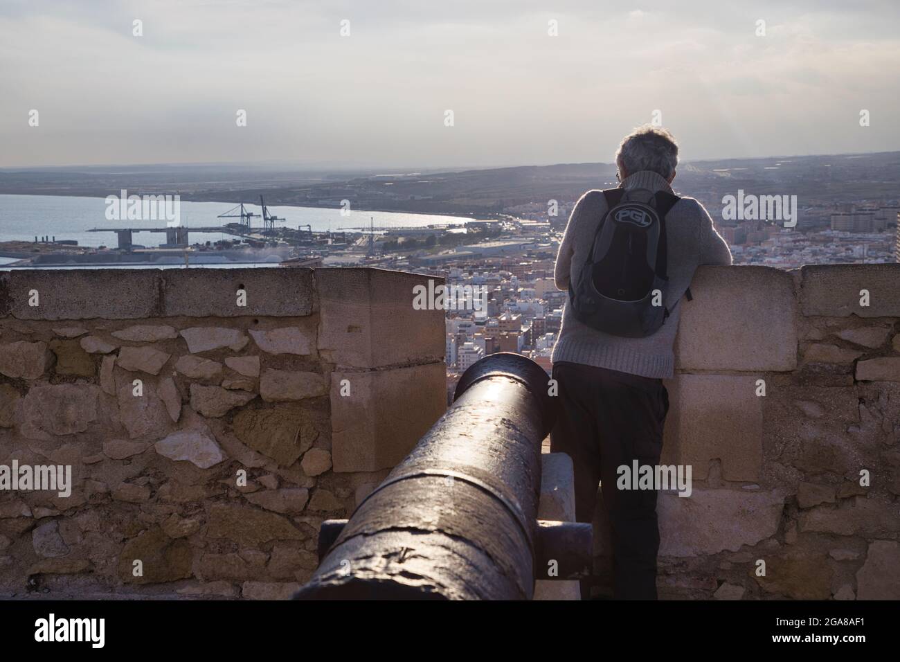 An old cannon at Santa Barbara castle in Alicante, Spain, points over the city from high up on the top of the castle walls Stock Photo