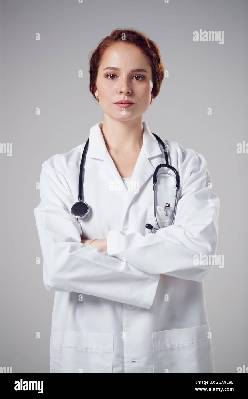 Studio Portrait Of Serious Young Female Doctor Wearing White Coat ...