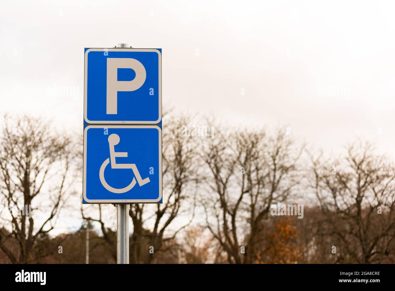 Handicap parking sign by a parking lot. Stock Photo