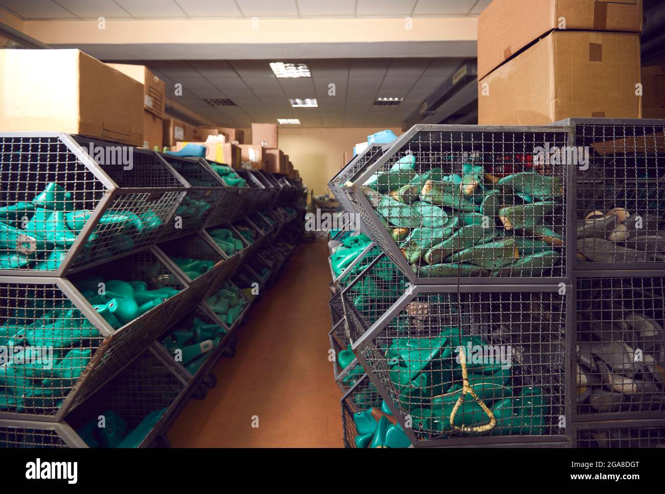 Aisle between rows of containers full of shoe lasts in a warehouse of a