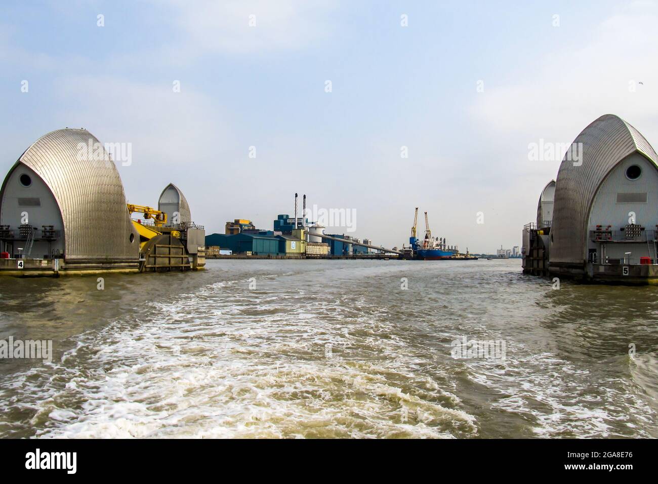 Looking through two of the steel clad shells off the Thames Barrier in its open position, Silvertown, UK. This retractable barrier system were created Stock Photo