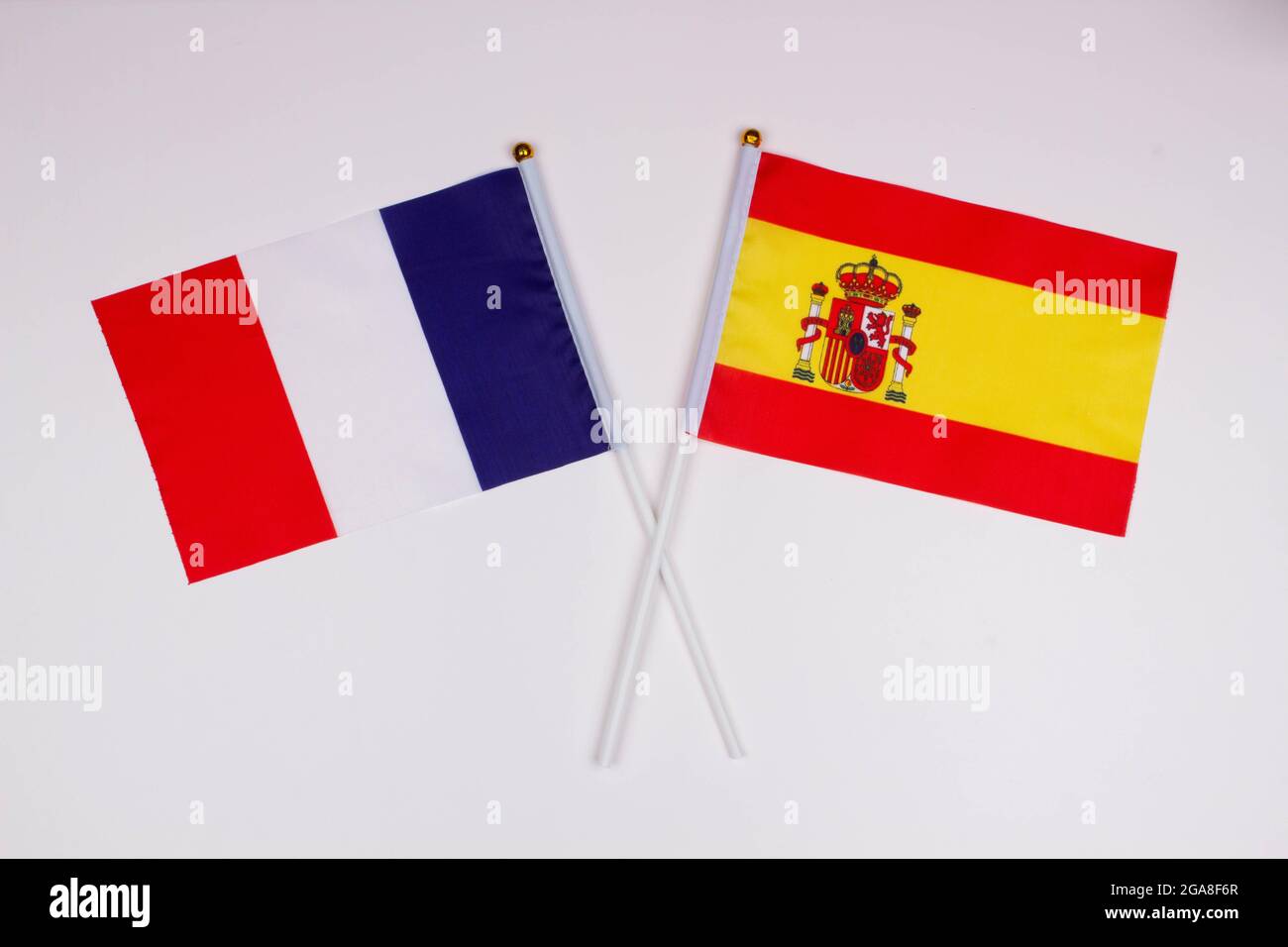 Flag of France and flag of Spain crossed with each other on a white