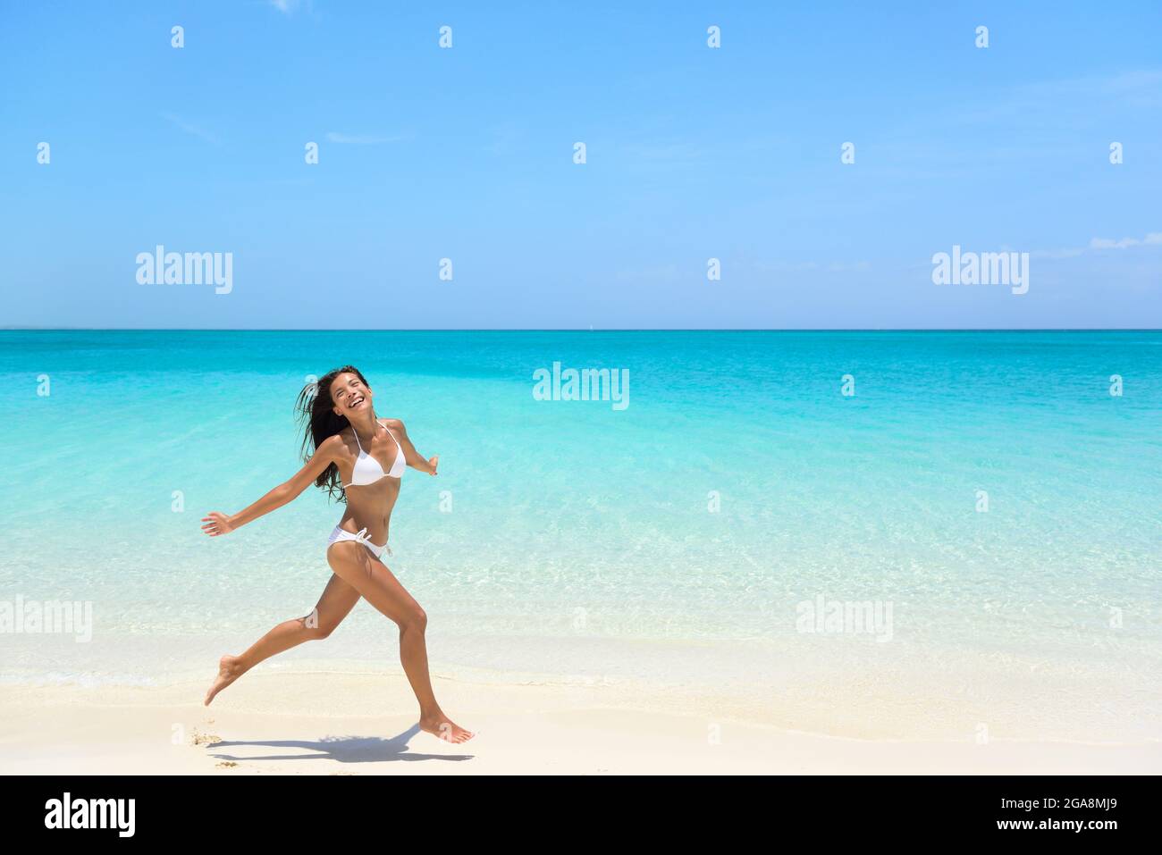 Carefree Woman Jumping On Beach during Summer Stock Photo