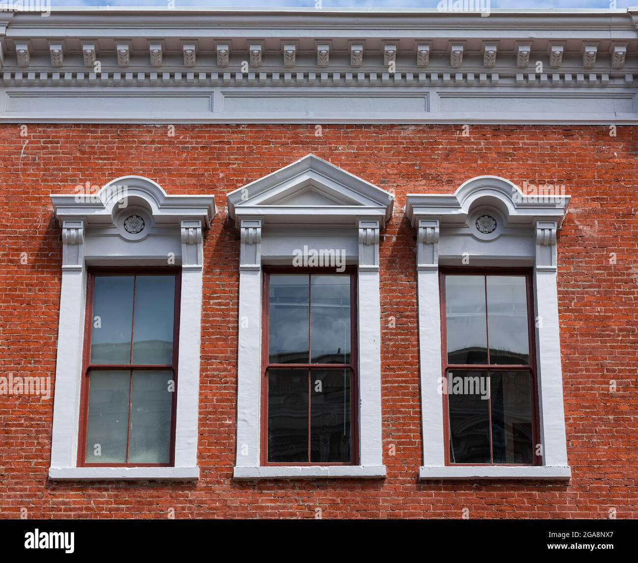 details of three arched windows in classic style on a brick wall of the
