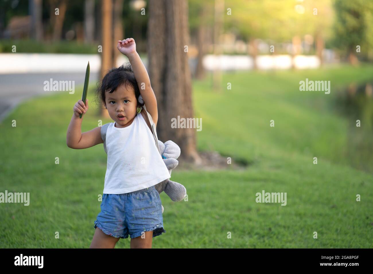 Adorable little girl playing in a park with toys Stock Photo - Alamy