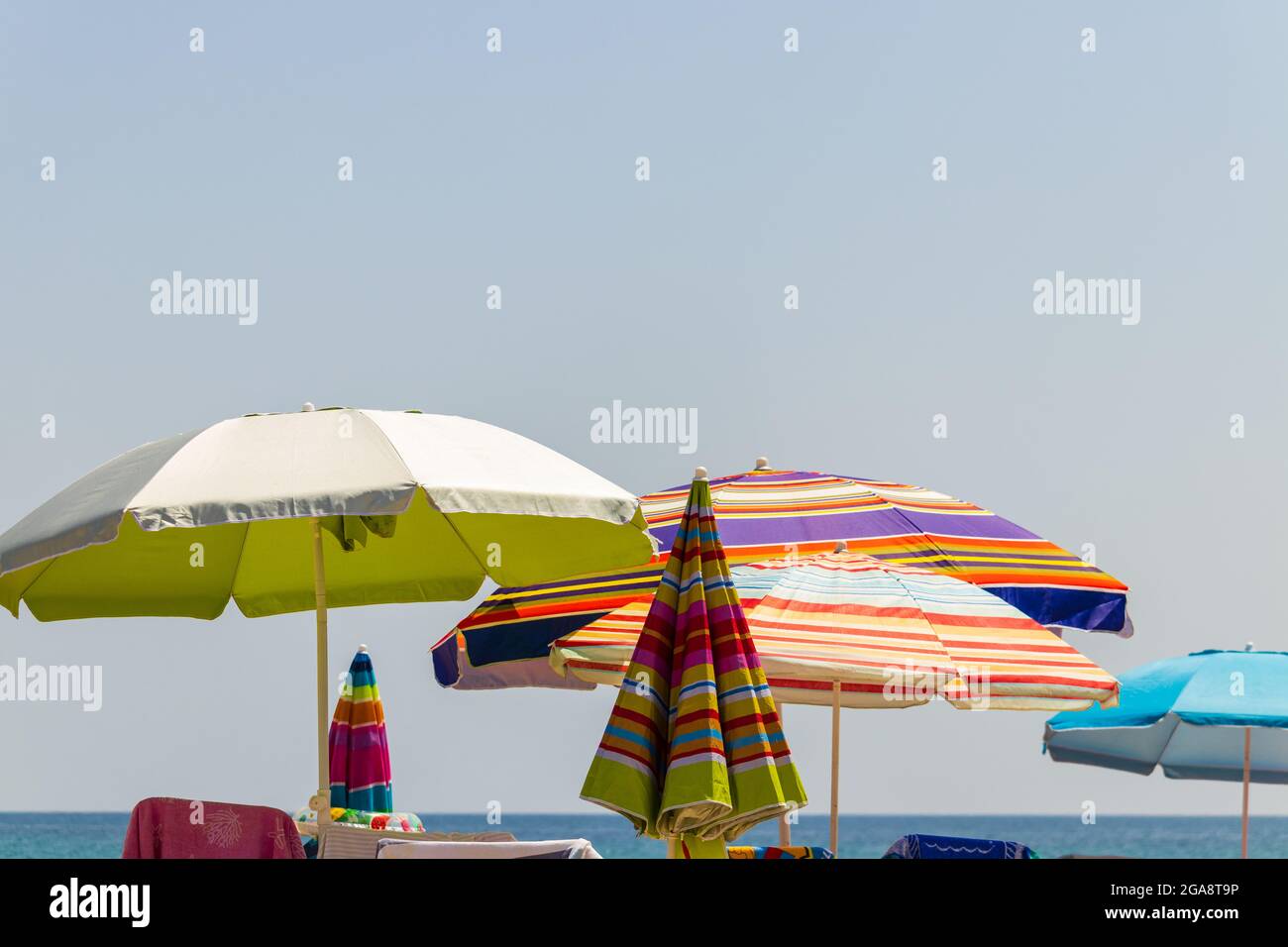 Colorful umbrellas on the beach during a sunny day with blue skies Stock Photo