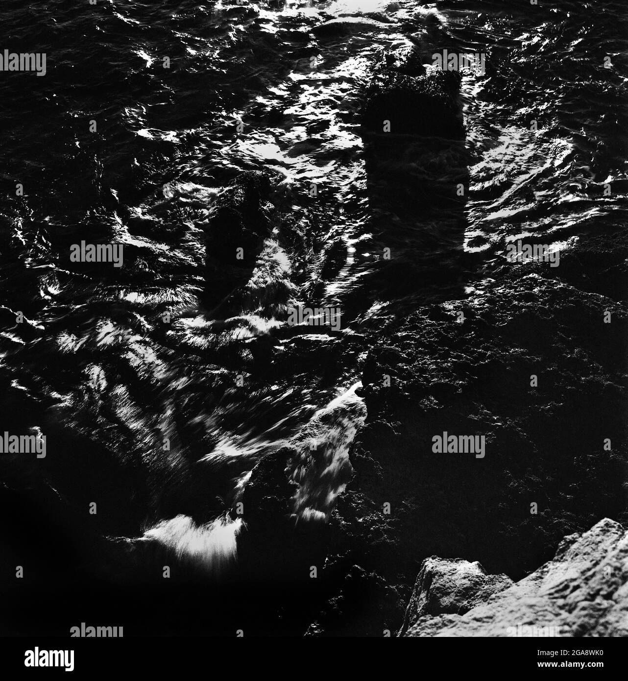 Black and white shot of waves crashing on the rocks and splashing Stock ...