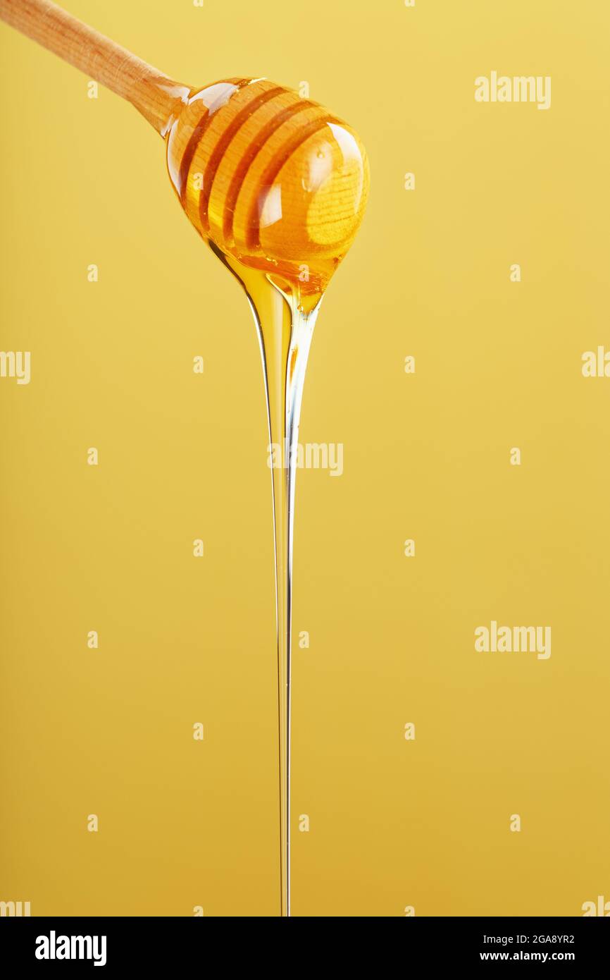 Honey Drips In A Thin Stream From A Honey Dipper On A Yellow Background Healthy Food Diet Concept Ecologically Pure Product Stock Photo Alamy