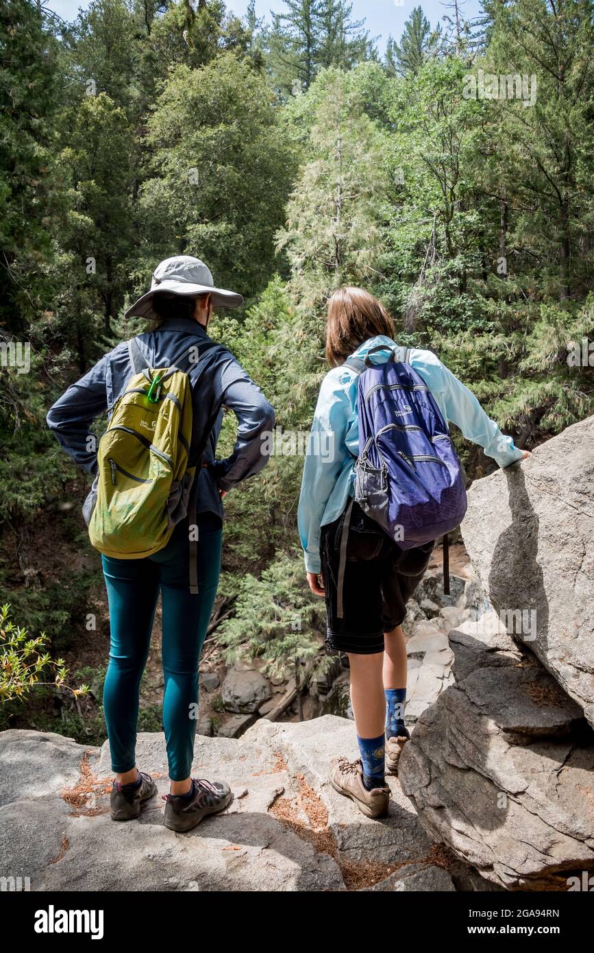 Teen female hikers pause to take in the view from an overlook on the Heart Rock Trail in San Bernardio Mountains. Stock Photo