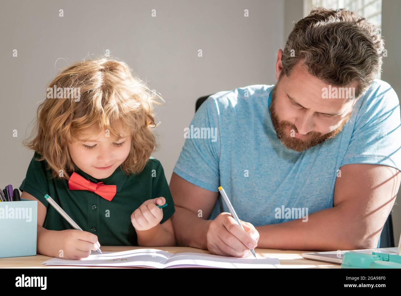 father and son painting at home. family help. boy do homework with teacher. Stock Photo